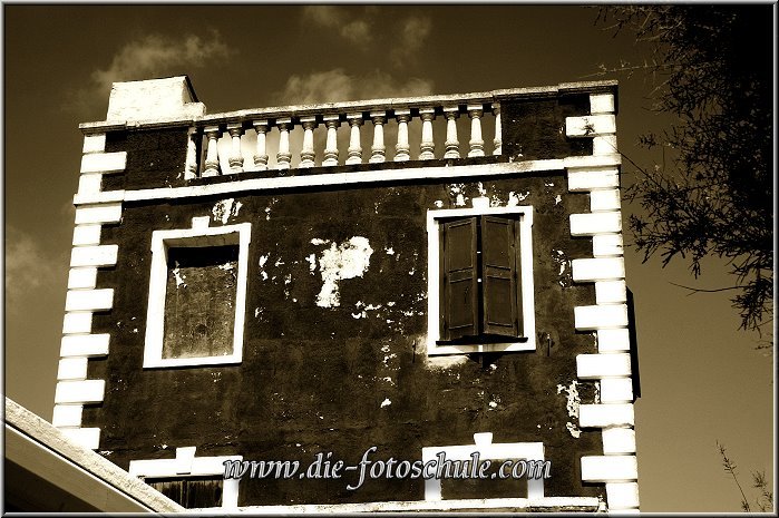 Es_Castell_10_ext.jpg - Eigentlich ist es ein rotes süßes Häuschen; die Färbung in sepia-monochrome gibt dem Haus etwas Bedrohliches. Da fehlt eigentlich nur noch ein schwarze Kutte oben am Geländer....